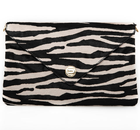 A black and white zebra-patterned clutch Elaine Turner Handbag with signature metallic ET logo plate on the front.