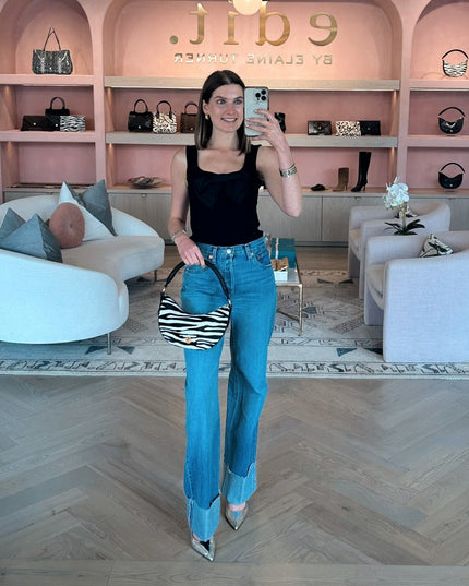 Edward Achour Black tank top with detachable bow, worn with Re/Done denim jeans and Elaine Turner Zebra haircalf Sawyer bag.