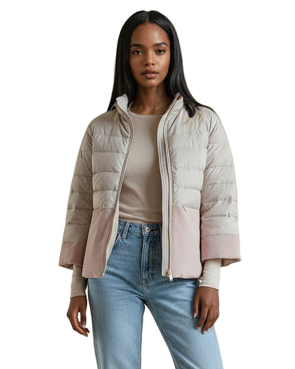 Woman wearing a puffer jacket off white with pink suede The Audrey from Cortland Park, beige top, and blue jeans in a minimalistic room at edit. BY ELAINE TURNER