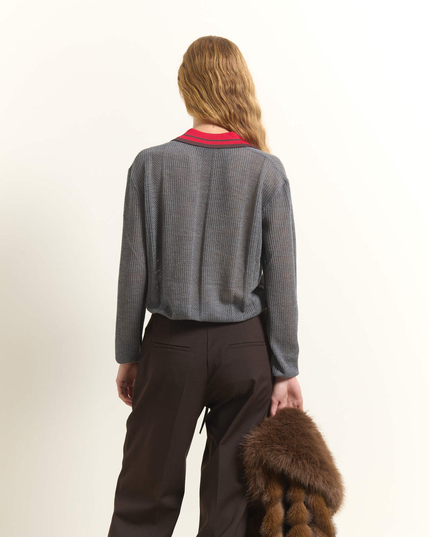 A woman shown from behind wearing a gray textured knit cardigan over a red collared shirt, paired with dark brown trousers, holding a brown fur accessory against a plain off-white background.

Beatrice B wool, silk and cashmere polo sweater in cloud gray. Available at Edit by Elaine Turner in Houston, TX. Back Model View. 