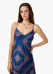 Woman wearing a blue patterned slip dress on a white background. CAMI NYC Becky Lace Trim Midi Dress in Mariner's Bandana at Edit by Elaine Turner. Front View. 