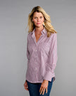 A woman modeling a long-sleeve button-up shirt with thin red and blue vertical stripes on a light pinkish base, paired with dark blue jeans, against a solid gray studio background.

Claridge & King- The 4..0 Shirt in Ross Stripe. Available at Edit by Elaine Turner in Houston, TX. Model Front View 
