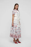 Woman wearing a floral dress on a white background. Dea Kudibal Lunadea Midi Dress at edit. By Elaine Turner. Model is showing the side view. 