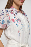 Woman wearing a floral dress on a white background. Dea Kudibal Lunadea Midi Dress at edit. By Elaine Turner. Model is showing a close-up view. 