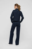 A woman stands with her back to the camera wearing a dark navy blue denim jacket and matching wide-leg denim pants against a light gray studio 
background.

Dea Kudibal- Wilma Denim Jacket Dark Blue. Available at Edit by Elaine Turner in Houston, TX. Full model back view. 