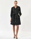 Woman wearing a dark denim dress with gold buttons on a white background by Dea Kudibal