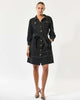 Woman wearing a dark denim dress with gold buttons on a white background by Dea Kudibal