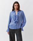 Diega Capa Blouse in Bleu. Available at Edit by Elaine Turner in Houston, TX. Model Close Up view. 