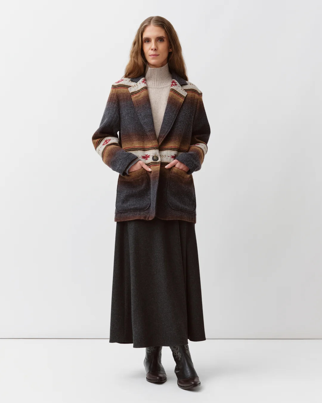 A model stands against a light gray studio background wearing a dark patterned jacket with brown and beige stripes, a cream turtleneck, a long dark skirt, and dark ankle boots.

Diega Virato Jacket in anthracite. Available at Edit by Elaine Turner in Houston, TX. Full front model view. 