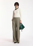 A model stands against a plain white studio background wearing a cream turtleneck sweater, wide-leg olive plaid trousers, a chunky brown necklace, and holding a dark green handbag.

Essentiel Antwerp - Kelmuse Knitted Pullover - Off White. Available at Edit by Elaine Turner in Houston, TX. Full model front view. 