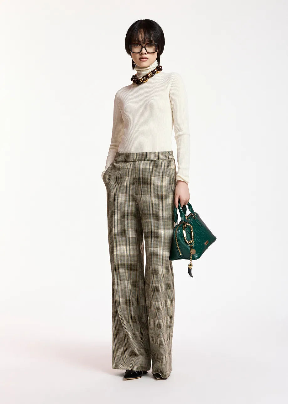A model stands against a plain white studio background wearing a cream turtleneck sweater, wide-leg olive plaid trousers, a chunky brown necklace, and holding a dark green handbag.

Essentiel Antwerp - Kelmuse Knitted Pullover - Off White. Available at Edit by Elaine Turner in Houston, TX. Full model front view. 