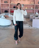 Woman taking a mirror selfie in a stylish interior setting in PINKO Brand Fall 2025 Apparel, balloon pants and sweater from Pinko at edit. BY ELAINE TURNER 