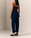 A woman is shown from behind wearing dark navy blue, softly sculpted barrel jean, a black strapless top, and black pointed-toe mule heels in a minimalist studio setting.

Le Jean Delphine Jean in Midnight Rodeo. Available at Edit by Elaine Turner in Houston, TX. Full model back view. 