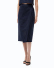 A model wearing a dark navy blue textured knit wrap midi skirt with a subtle dotted pattern, paired with black studded heels against a plain white background.

PINKO- Fully Rhinestoned Calf-Length Wrap Skirt in Iris Blue. Available at Edit by Elaine Turner in Houston, TX. Model Skirt view. 