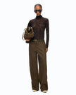 A model stands against a plain white background wearing a dark brown patterned turtleneck, wide-leg brown trousers, a dark belt with a gold buckle, sunglasses, and holding a brown bucket bag.

PINKO- Turtleneck Sweater with Floral Camouflage Print in Green & Black Multicolor. Available at Edit by Elaine Turner in Houston, TX. Full front model view. 