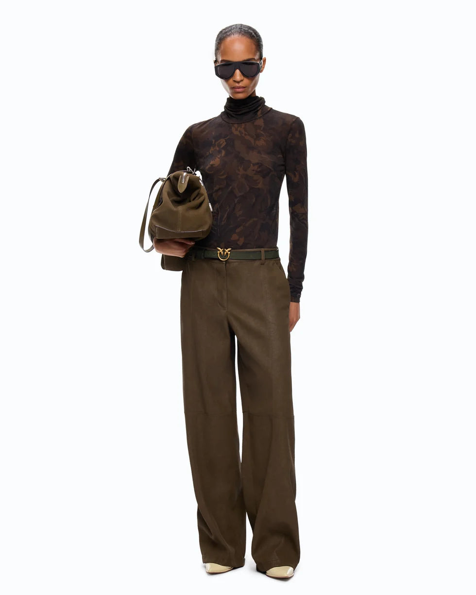 A model stands against a plain white background wearing a dark brown patterned turtleneck, wide-leg brown trousers, a dark belt with a gold buckle, sunglasses, and holding a brown bucket bag.

PINKO- Turtleneck Sweater with Floral Camouflage Print in Green & Black Multicolor. Available at Edit by Elaine Turner in Houston, TX. Full front model view. 