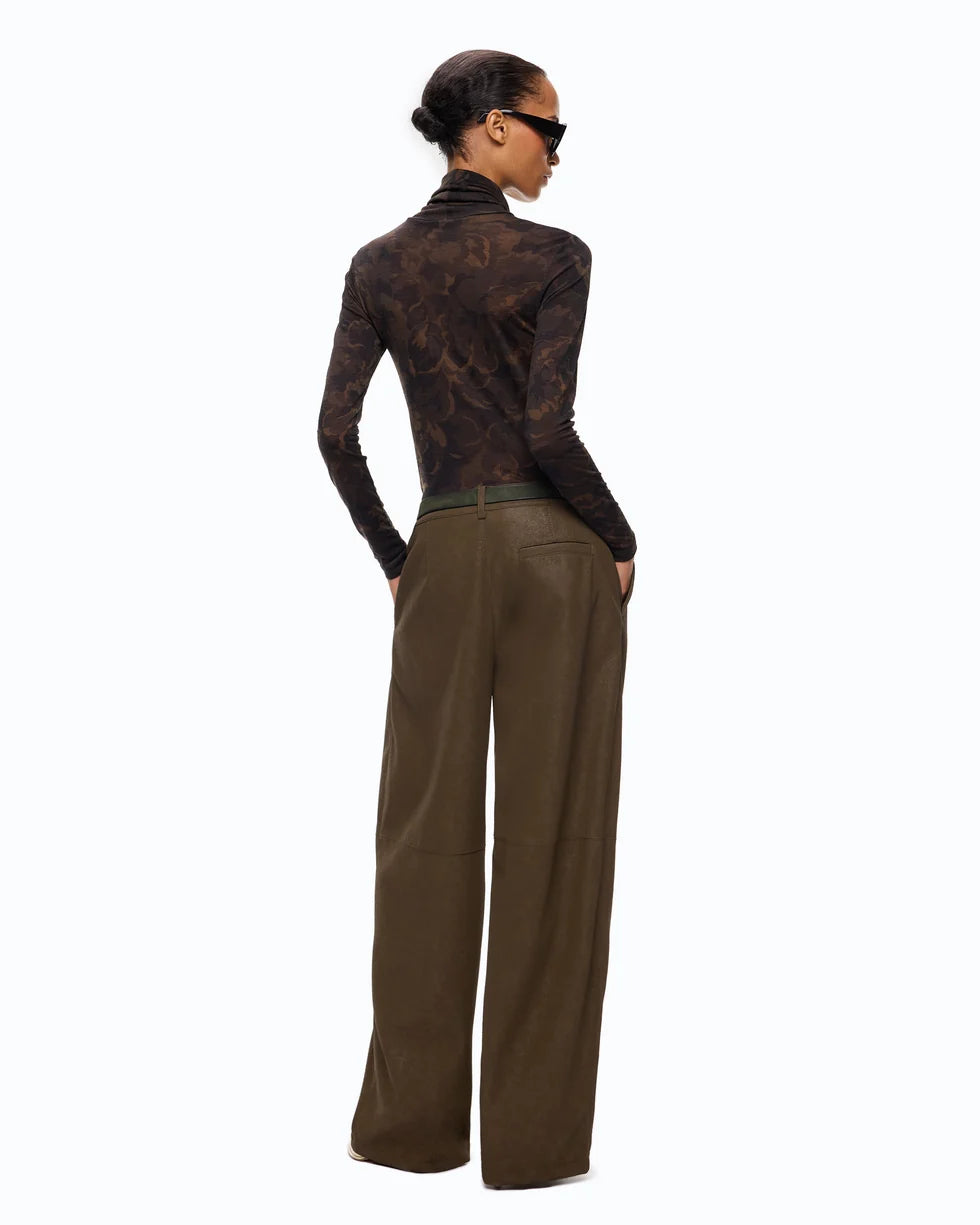 A model shown from the back wearing a dark brown patterned long-sleeve mock neck top and olive brown wide-leg trousers, styled with black sunglasses against a plain white background.

PINKO- Turtleneck Sweater with Floral Camouflage Print in Green & Black Multicolor. Available at Edit by Elaine Turner in Houston, TX. Full back model view. 