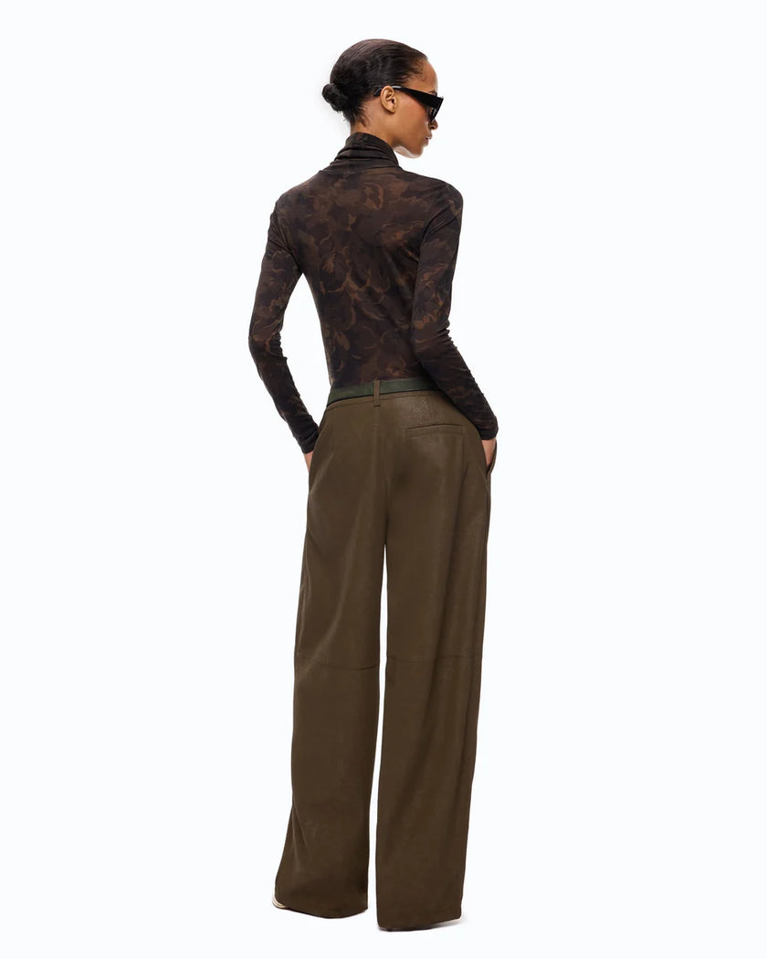 A model shown from the back wearing a dark brown patterned long-sleeve mock neck top and olive brown wide-leg trousers, styled with black sunglasses against a plain white background.

PINKO- Turtleneck Sweater with Floral Camouflage Print in Green & Black Multicolor. Available at Edit by Elaine Turner in Houston, TX. Full back model view. 