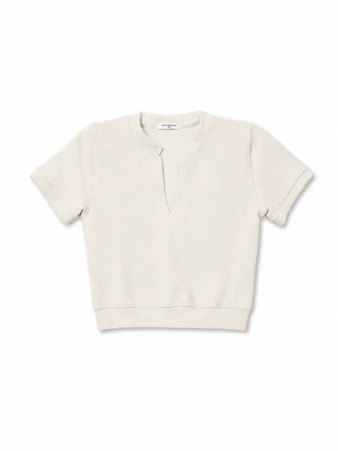 A short-sleeve crewneck sweatshirt in a light cream or off-white color, laid flat against a solid white background.

PerfectWhiteTee- Cleo French Terry short sleeve in Sugar. Available at Edit by Elaine Turner in Houston, TX. Flat lay View. 