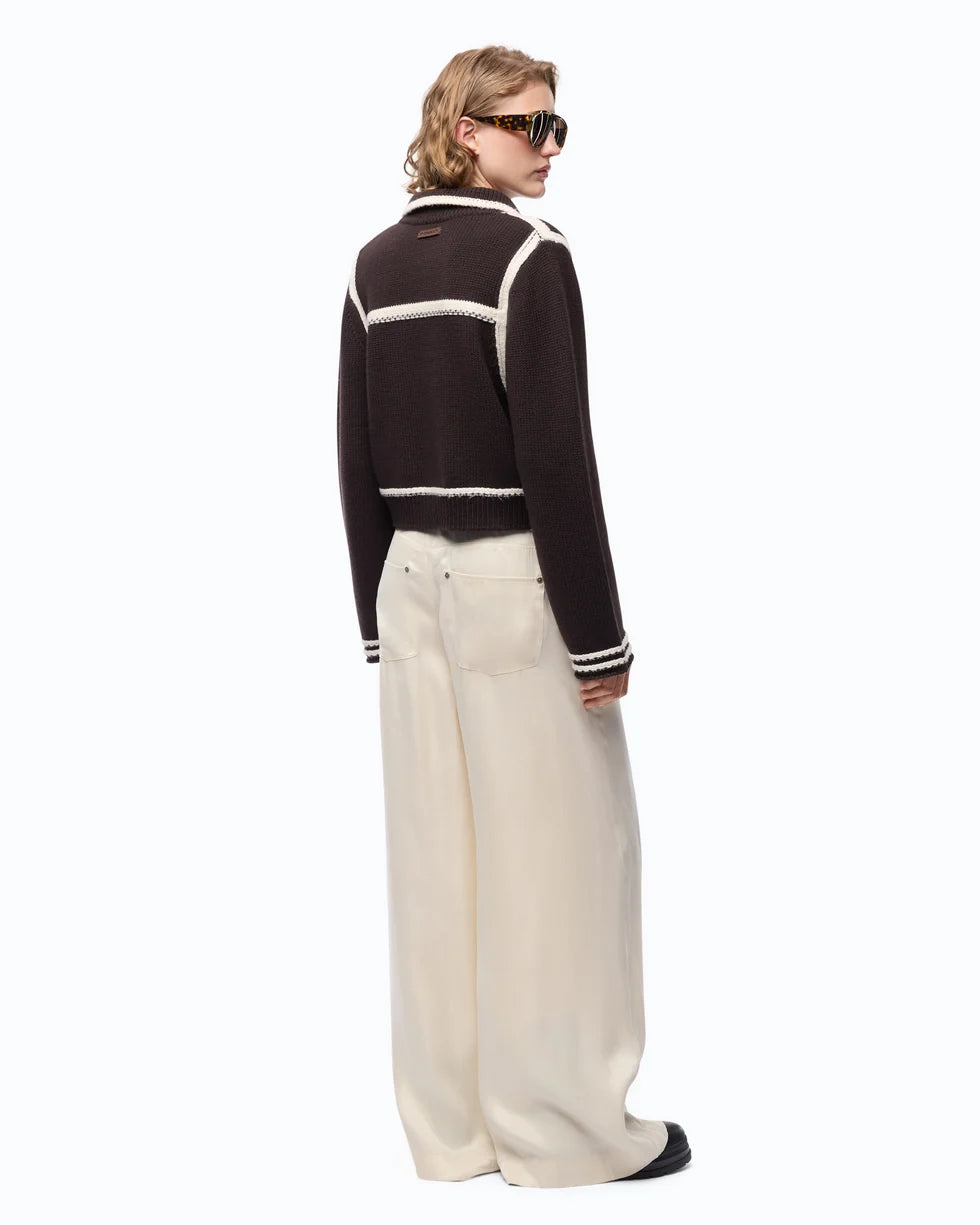 A model shown from the back wearing a brown cropped knit cardigan with white stripes, paired with cream wide-leg trousers and black sunglasses, against a plain white background.

Pinko New Sulcis Giacca. Available at Edit by Elaine Turner in Houston, TX Full model back view. 