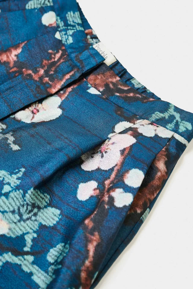 Blue fabric with floral pattern on a white background. 

Psophia Palazzo Trousers in Almond Blossom. Available at Edit by Elaine Turner in Houston, TX. Close-Up View. 