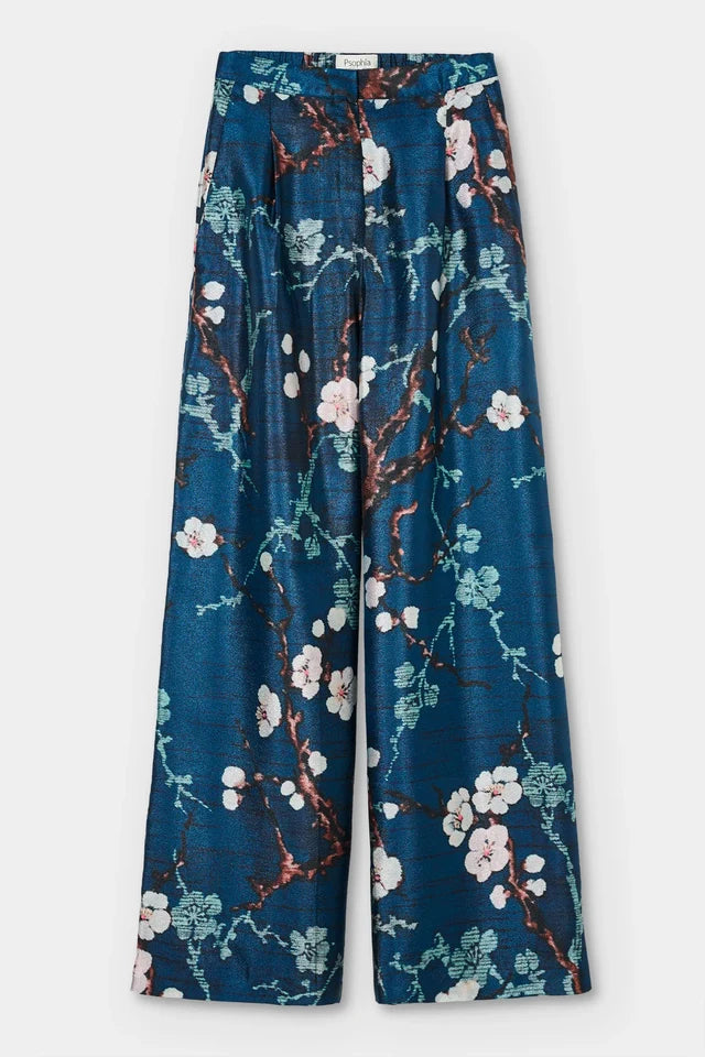 Floral-patterned pants on a white background. 

Psophia Palazzo Trousers in Almond Blossom. Available at Edit by Elaine Turner in Houston, TX. Flat Lay View. 