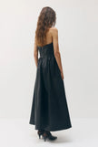 A woman viewed from the back wearing a strapless black midi dress with a structured bodice and flared skirt, paired with black pointed heels, against a plain light gray studio background.

Sabina Musayev Garner Dress in black. Available at Edit by Elaine Turner in Houston, TX. Back Model View. 