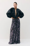 A model stands against a plain light gray studio background wearing a black vegan leather cropped jacket with voluminous sleeves and a matching sheer black maxi skirt with a dark purple floral print.

Sabina Musayev Tomas Jacket in black. Available at Edit by Elaine Turner in Houston, TX. Front Model View. 
