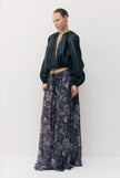 A model stands against a plain light gray studio background wearing a black vegan leather cropped jacket with long sleeves and a dark floral maxi skirt with purple and gray tones.

Sabina Musayev Tomas Jacket in black. Available at Edit by Elaine Turner in Houston, TX. Front Side Model View. 