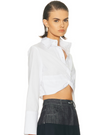 Model wearing a white cropped twist shirt, aa modern take on menswear from Matthew Bruch at edit. BY ELAINE TURNER boutique in Houston  on a white background